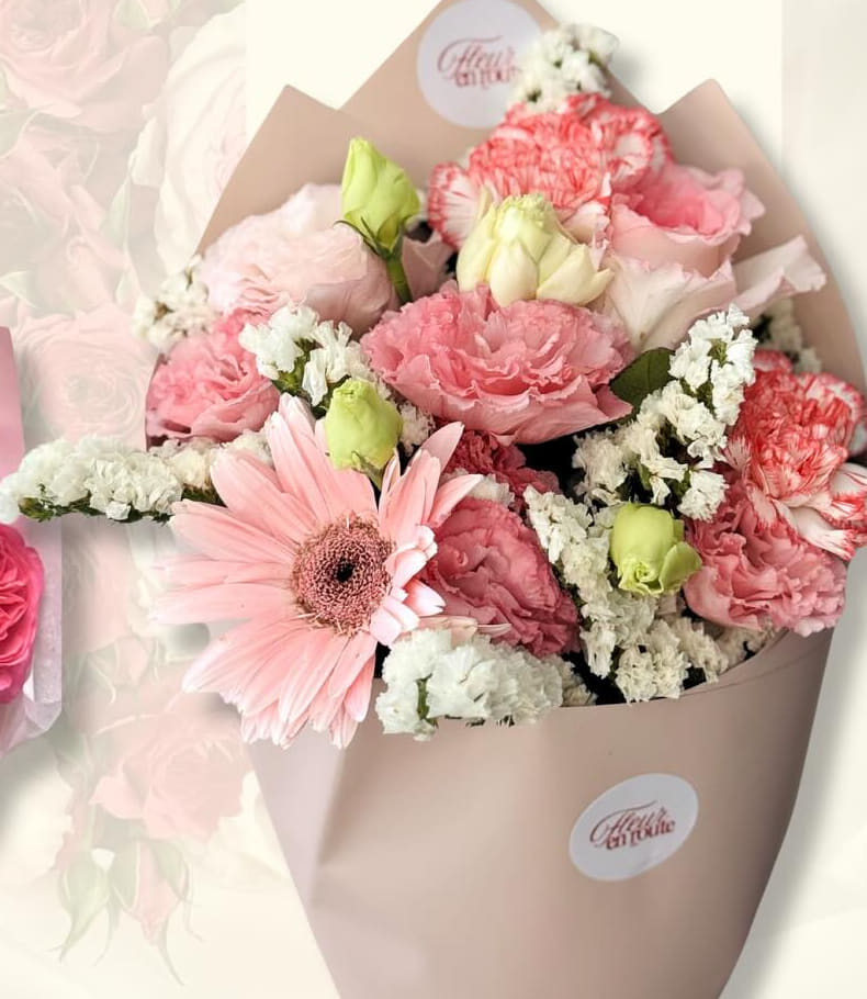 Pastel bouquet of pink carnations, lisianthus, and a pale gerbera in cream wrap
