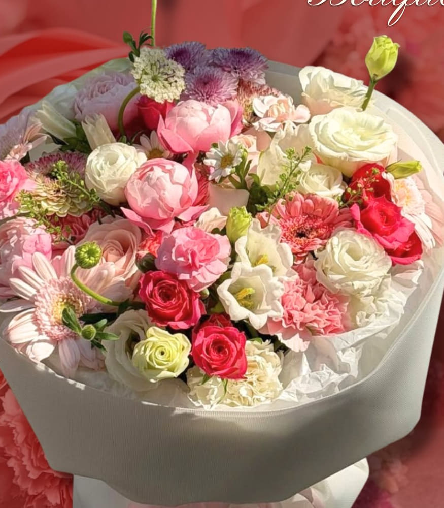 Large pink and white bouquet of roses, lisianthus, and gerberas in white wrap